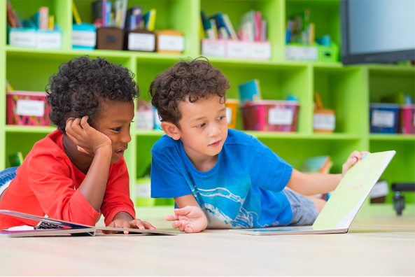 Two boys reading a book